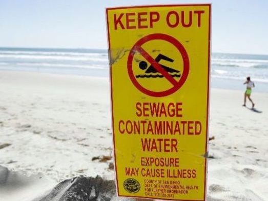 In this 2017 photo, a sign warns of sewage-contaminated ocean waters in South Bay San Diego.