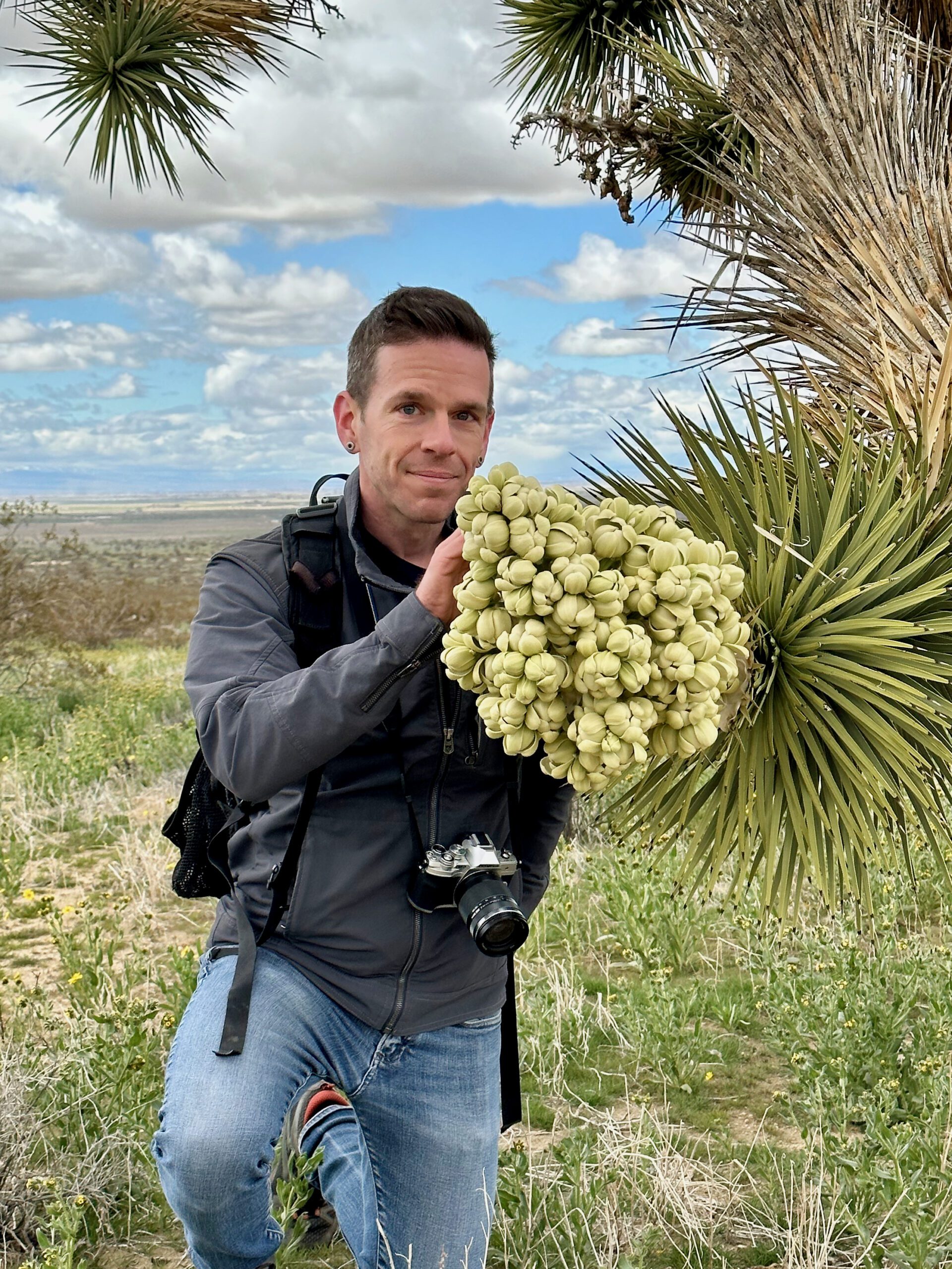 Professor Jeremy Yoder poses with a Joshua tree flower | Colin MacDonald